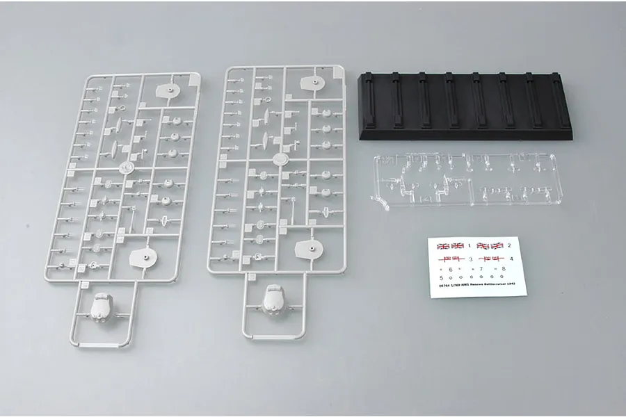 Trumpeter 1/700 scale HMS Renown 1942 model kit parts including two grey plastic sprues, a black display stand, clear parts, and a decal sheet.