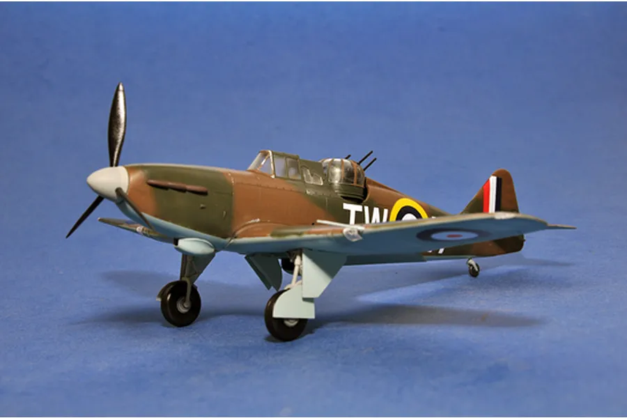 A completed 1/48 scale plastic model of a Boulton Paul Defiant fighter plane with camouflage paint and RAF markings, set against a blue background.