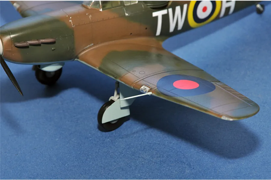 A close-up view of a scale model Boulton Paul Defiant aircraft featuring camouflage paint, RAF roundels, and the code TW-H on the fuselage.