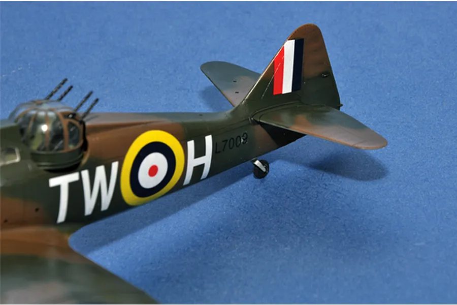 A close-up of the rear fuselage of a Boulton Paul Defiant model aircraft, showing the gun turret, RAF roundel, and tail markings on a blue background.