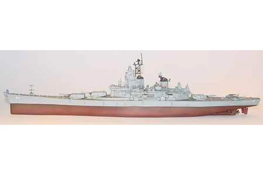 A side-profile view of a completed 1/700 scale plastic model of the USS Missouri battleship, painted in grey with a red hull.
