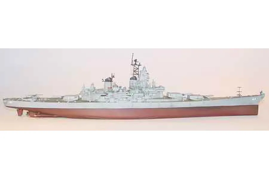 A side-profile view of a completed 1/700 scale plastic model of the USS Missouri battleship, painted in grey and hull red.