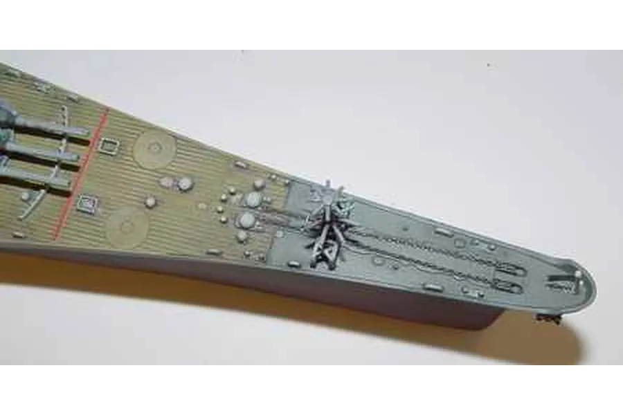 Close-up of the bow section of a 1/700 scale USS Missouri battleship model kit showing deck details, anchor chains, and gun turrets.