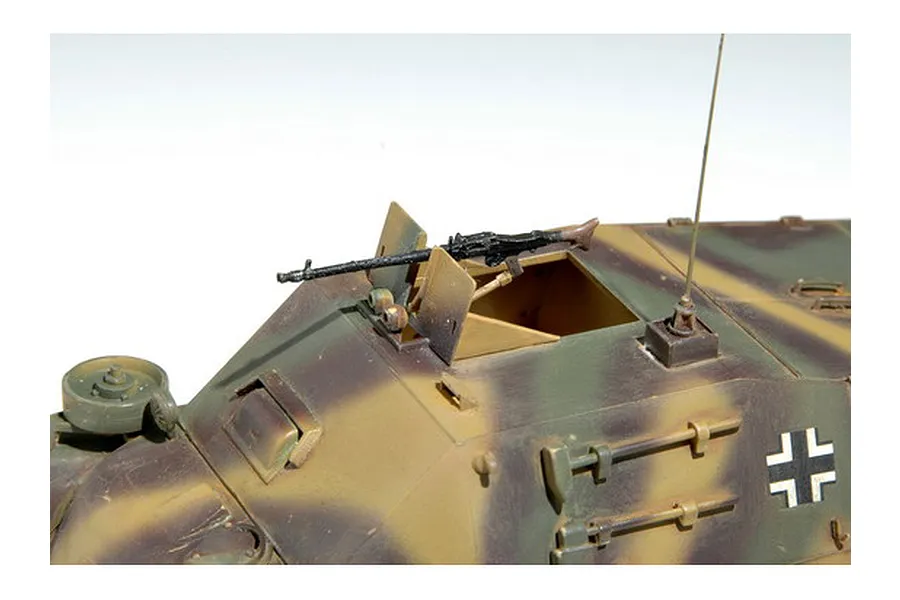 A close-up view of a 1/35 scale German military vehicle model featuring a mounted machine gun, antenna, and camouflage paint scheme.
