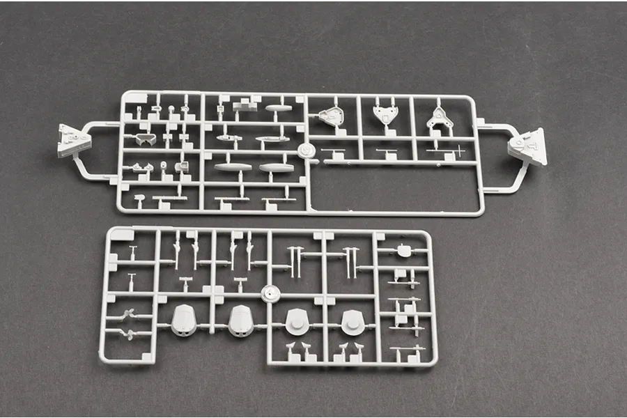 Two grey plastic model kit sprues containing various small battleship parts on a dark grey background.