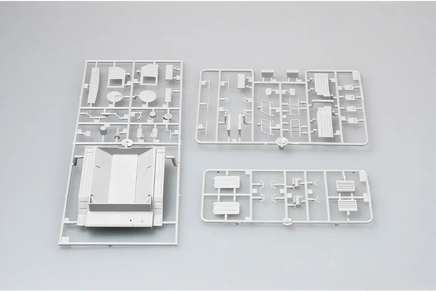 Three grey plastic model kit sprues containing various vehicle parts for a 1/35 scale military truck model.