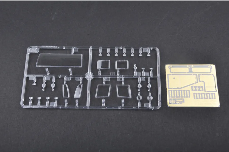 A clear plastic sprue containing various window parts and a small photo-etched metal sheet for a 1/35 scale model kit.