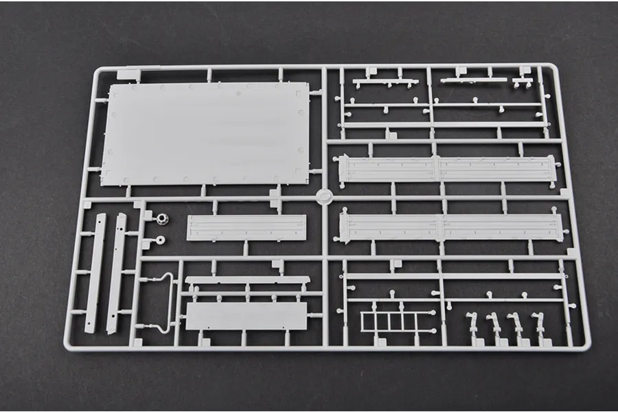 A grey plastic model kit sprue containing various flat panels and structural components for a 1/35 scale military vehicle model.