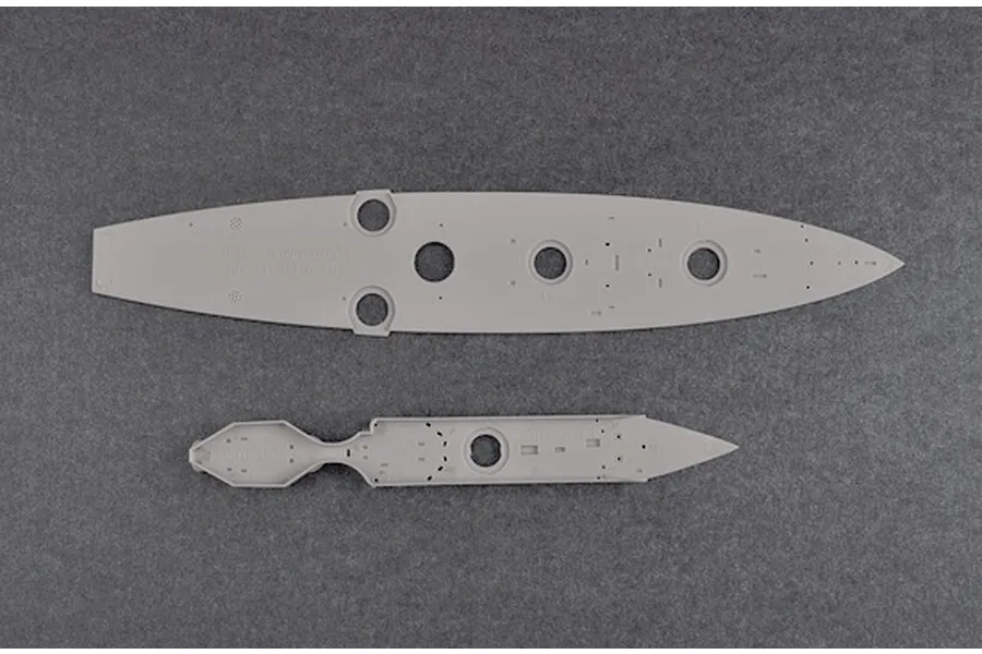 Two grey plastic model ship deck parts from a Trumpeter 1/700 HMS Dreadnought kit, viewed from above on a dark grey background.