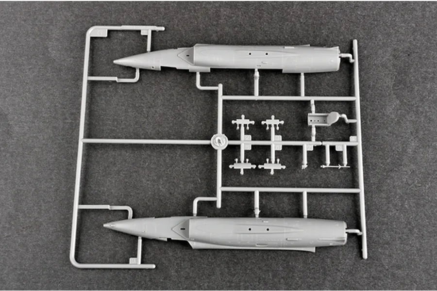 A grey plastic sprue from a Trumpeter 1/72 scale model kit containing aircraft fuselage halves and small cockpit components.