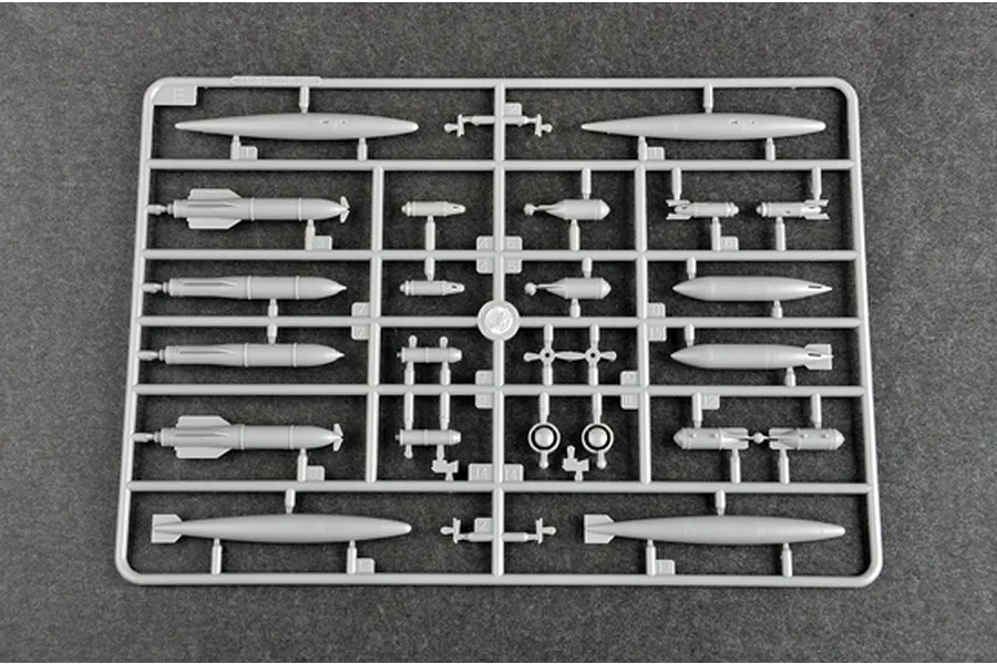 A grey plastic sprue containing various model aircraft weapon components, including bombs and fuel tanks, for a 1/72 scale model kit.