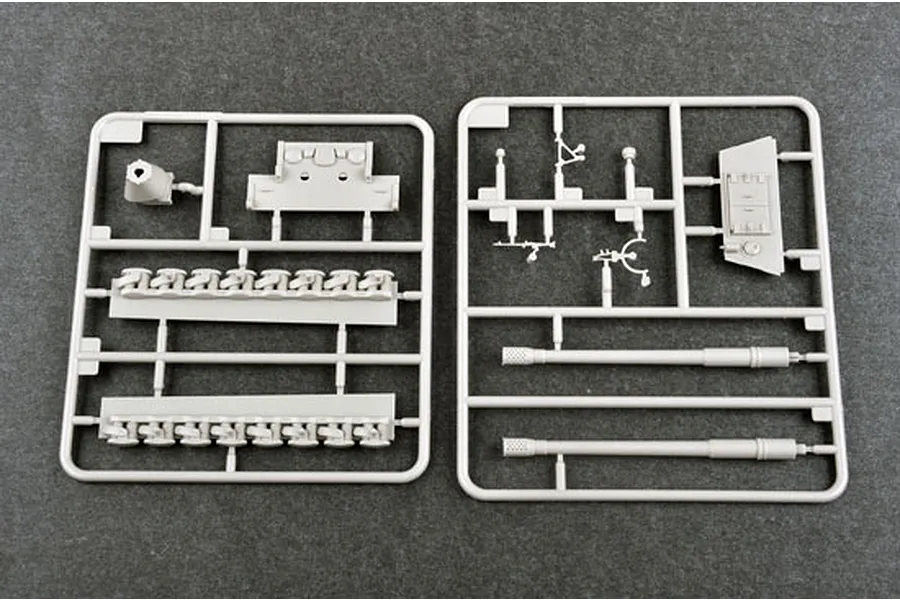 Two grey plastic model kit sprues containing tank parts including gun barrels, tracks, and hull components on a dark grey background.