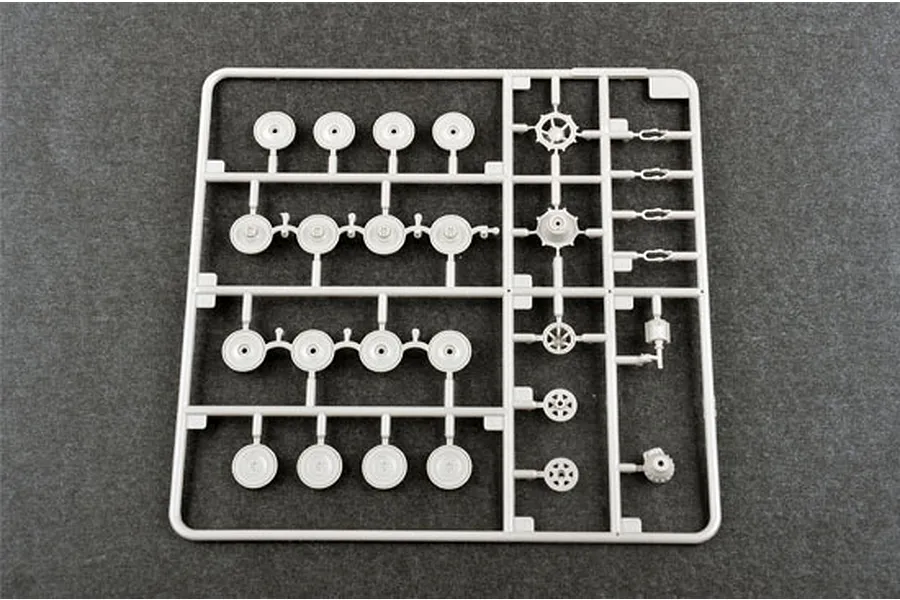 A grey plastic model kit sprue containing various road wheels and sprocket parts for a 1/72 scale tank model.