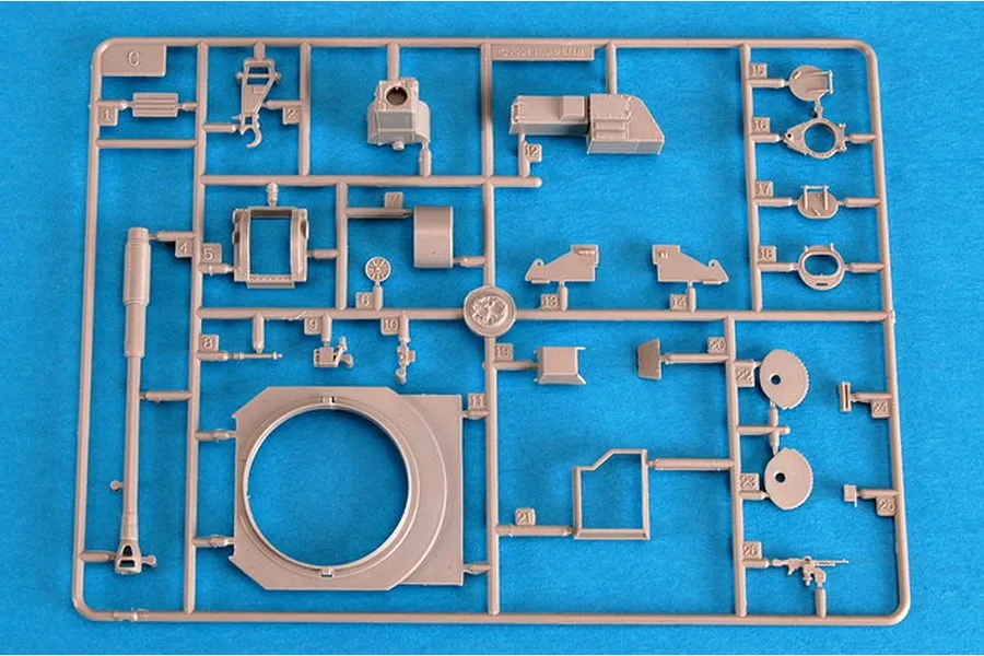 A plastic model kit sprue labeled C, containing various grey parts for a 1/72 scale military vehicle model, set against a bright blue background.