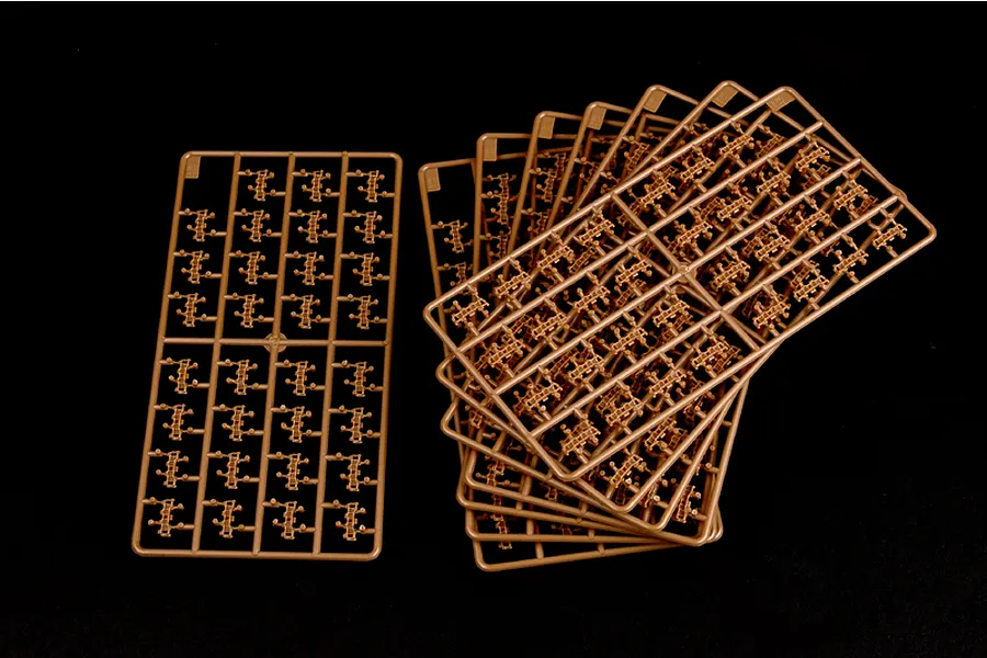Several brown plastic model tank track sprues arranged on a black background.