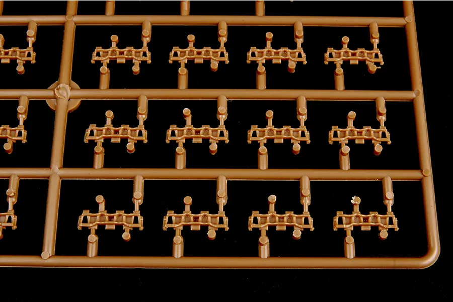 A close-up view of a brown plastic model kit sprue containing multiple individual tank track links for a 1/35 scale model.