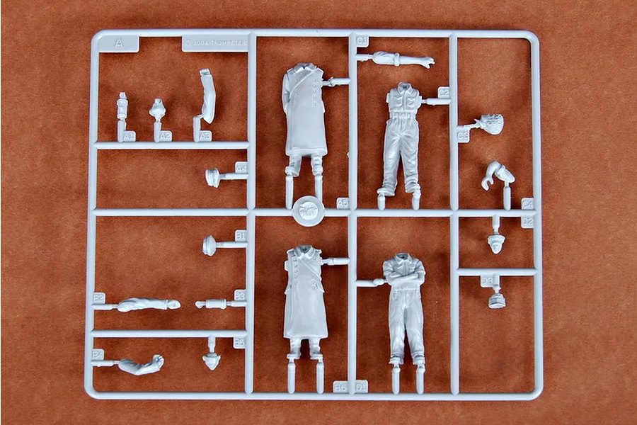 A grey plastic sprue containing unpainted model soldier parts for a 1/35 scale German artillery crew kit.