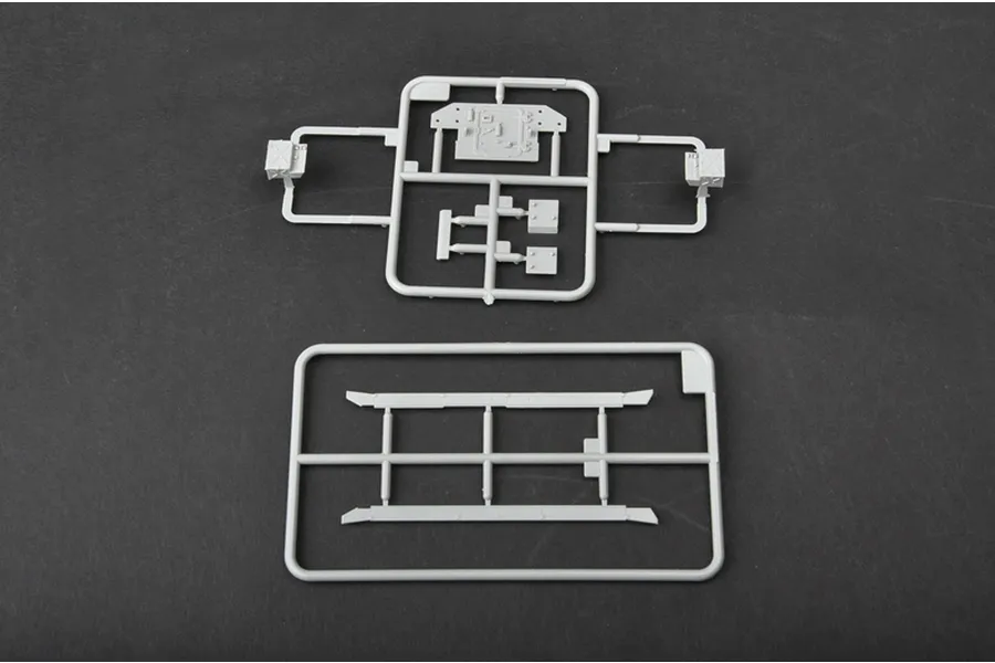 Two grey plastic model kit sprues containing various small tank parts on a dark grey background.