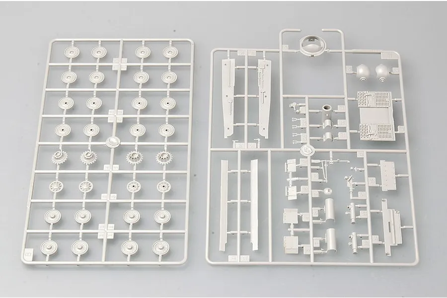 Two light grey plastic model kit sprues containing various tank parts, including road wheels, drive sprockets, and hull components.
