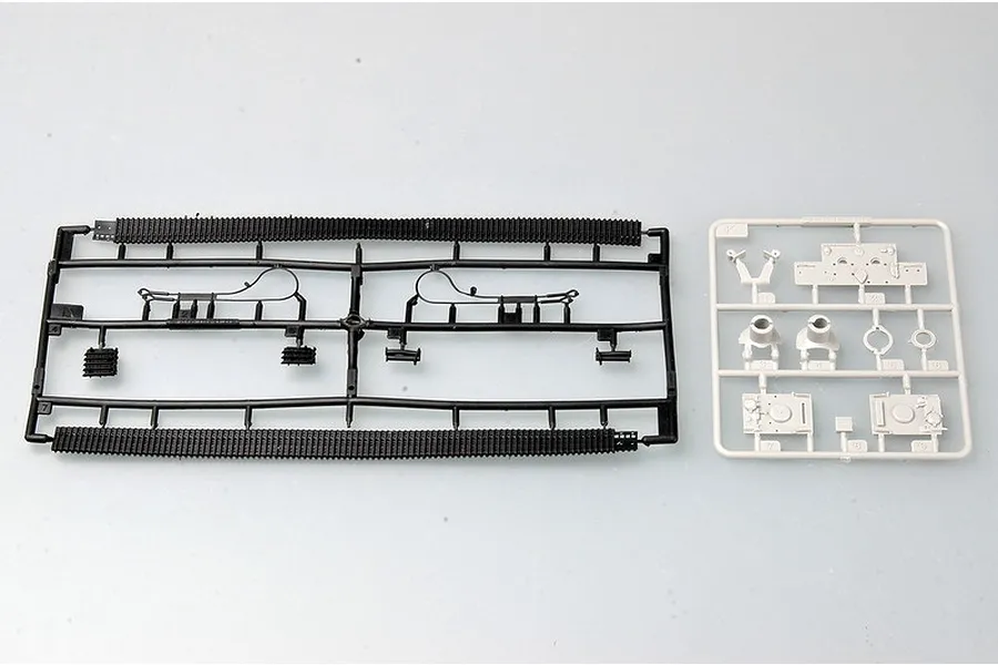 Two plastic model kit sprues for a 1/72 scale tank, one black with tank tracks and one light grey with small vehicle parts.