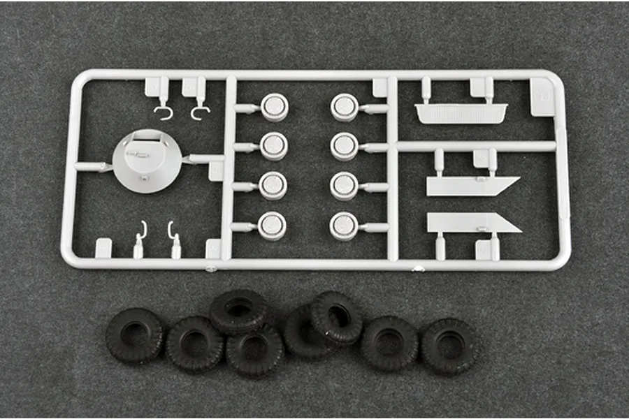 A grey plastic model kit sprue containing vehicle parts and a set of eight black rubber tires for a 1/72 scale BTR-70 APC model.