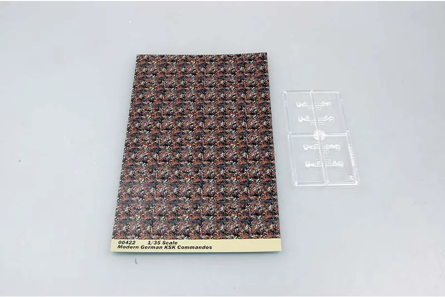 A sheet of camouflage pattern decals and a small clear plastic sprue for a 1/35 scale Trumpeter German Modern KSK Commandos model kit.