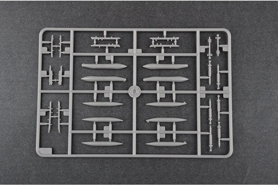 A grey plastic sprue containing model aircraft parts, including fuel tanks and missiles, for a 1/144 scale model kit.