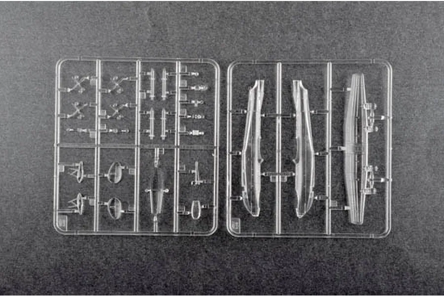 Two clear plastic model kit sprues containing small aircraft parts on a dark grey background.