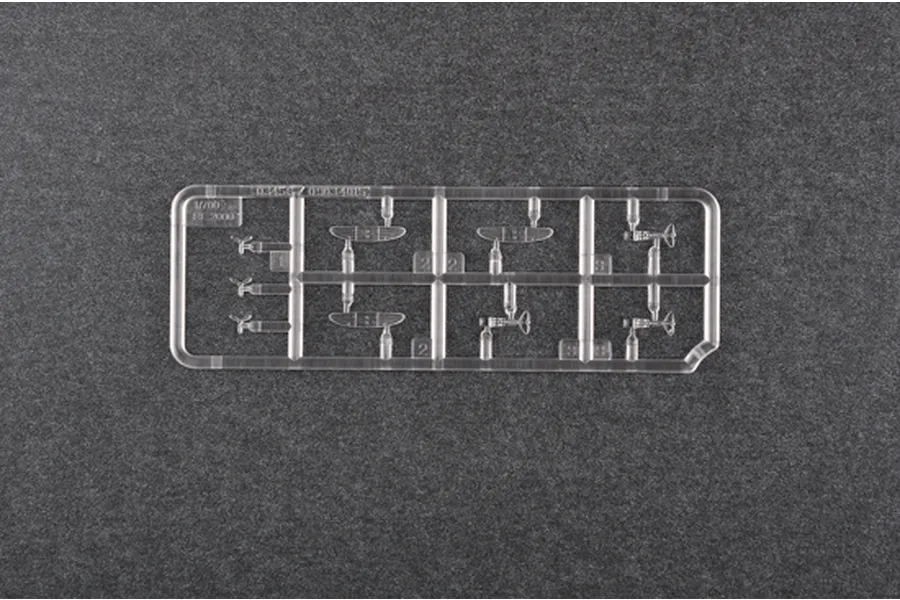 A clear plastic sprue containing miniature 1/700 scale Re.2000 aircraft parts for a model kit, set against a dark grey textured background.