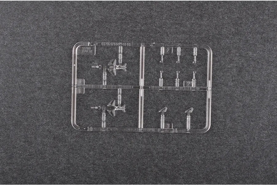 A clear plastic sprue containing two 1/700 scale YAK-38 aircraft model parts and additional components on a dark grey background.