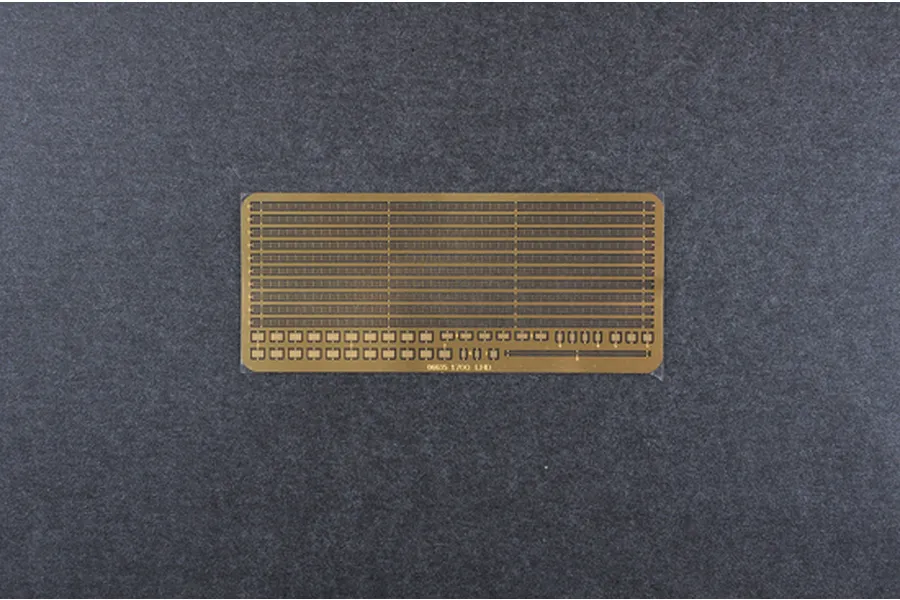 A brass photo-etched detail set for 1/700 scale model ships, featuring handrails and safety nets, displayed on a dark grey surface.