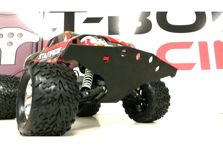 A low-angle close-up of a Traxxas Stampede RC truck fitted with a wide black T-Bone Racing front basher bumper.