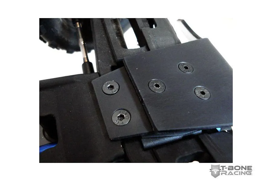 Close-up of a T-Bone Racing black bumper installed on the front of an RC vehicle chassis.