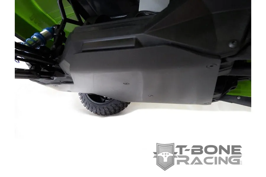 A T-Bone Racing skid plate installed on the underside of an Axial Yeti Score RC trophy truck, showing the black protective panel.