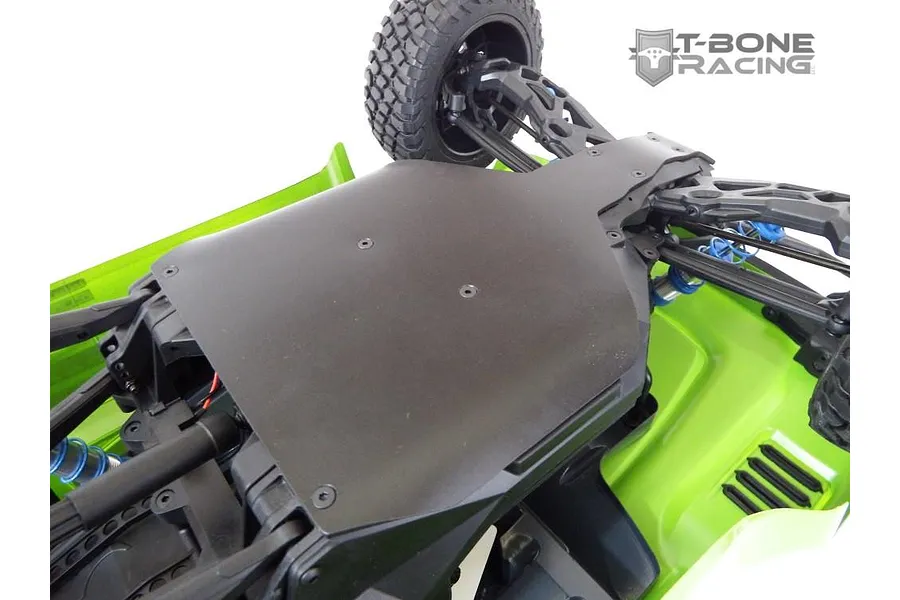 A T-Bone Racing black skid plate installed on the underside of a green Axial Yeti Score Trophy RC truck.
