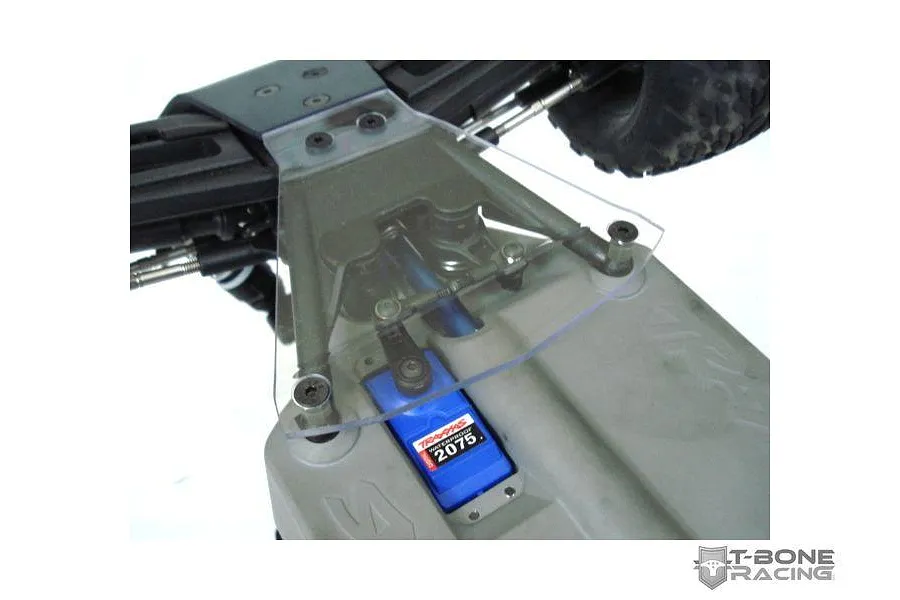 A clear T-Bone Racing servo guard installed on a Traxxas Stampede 4x4 RC chassis, protecting the blue Traxxas 2075 servo.