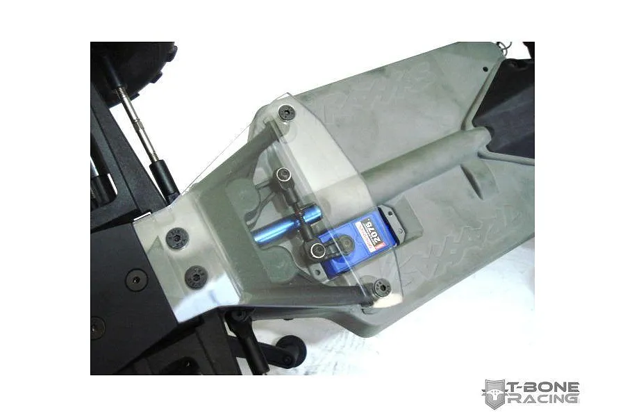 A clear T-Bone Racing servo guard installed on a Traxxas Stampede 4x4 RC chassis, protecting the blue Traxxas 2075 servo.