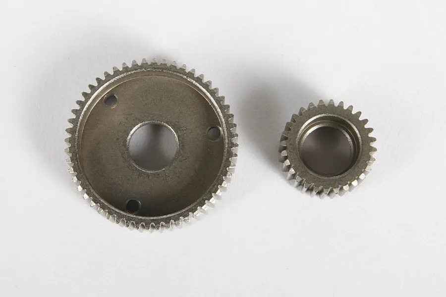 Two metal RC transmission gears of different sizes resting on a plain white background.