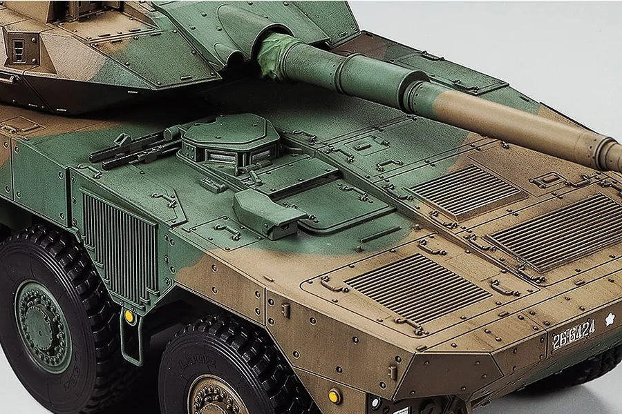 A high-angle close-up of a painted 1/35 scale Tamiya JGSDF Type 16 combat vehicle model showing the turret, main gun, and camouflage hull details.