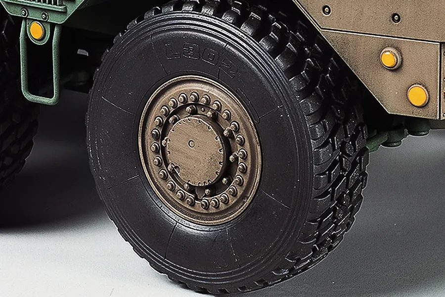 Close-up of a detailed rubber tire and wheel assembly on a Tamiya 1/35 scale JGSDF Type 16 Combat Vehicle model kit.