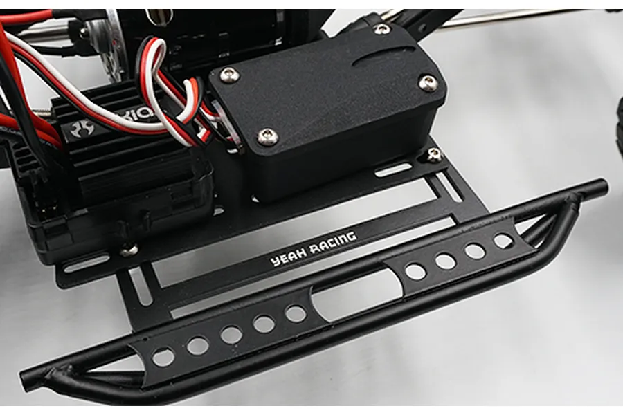 A black metal side step rock rail with a receiver box mounted on an RC chassis, featuring the Yeah Racing logo.