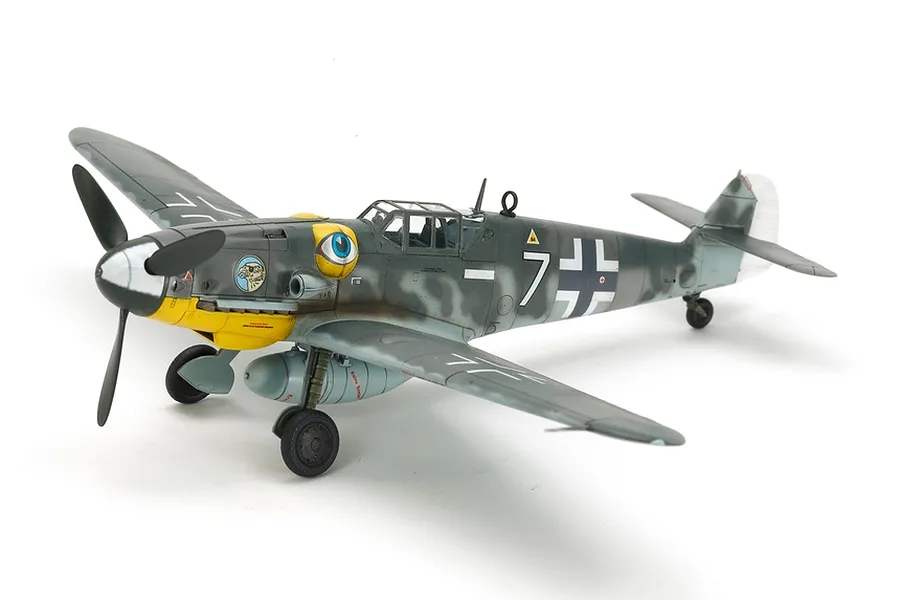 A fully assembled and painted 1/72 scale Tamiya Messerschmitt Bf109 G-6 model aircraft, featuring a grey camouflage scheme, yellow nose, and eye decal.