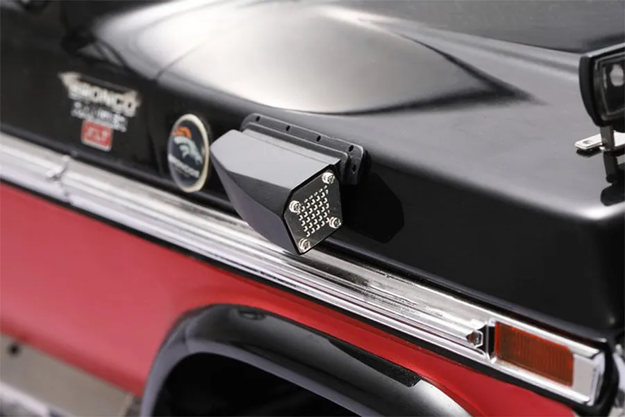 A black GPM Racing fender vent accessory installed on the side of a black and red Traxxas TRX-4 Ford Bronco RC body shell.