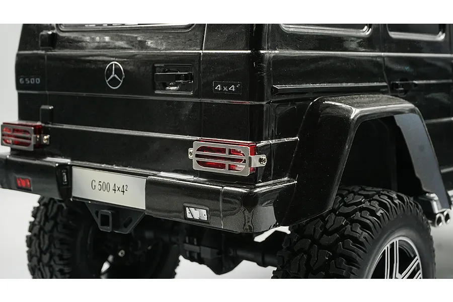 Close-up of a black RC Mercedes-Benz G 500 model car showing the rear taillight protector grill installed over the red taillight lens.