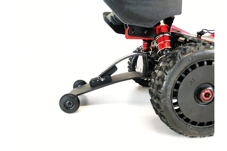 A T-Bone Racing wheelie bar installed on the rear of an ARRMA Typhon RC buggy, showing the black plastic bar and small wheels against a white background.
