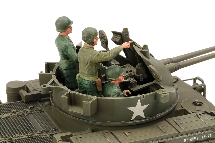 A close-up view of a 1/35 scale Tamiya M42 Duster model tank turret with three painted crew figures, featuring olive drab plastic and a white star decal.
