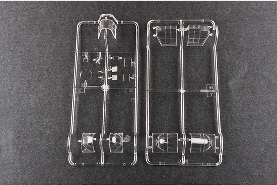 Two clear plastic model kit sprues containing aircraft canopy and window parts on a dark grey background.