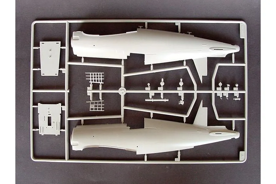A grey plastic sprue containing fuselage halves and small interior parts for a 1/32 scale model aircraft kit.