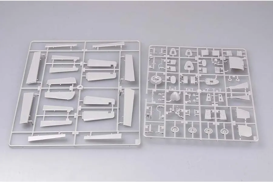 Two grey plastic model kit sprues containing various aircraft parts, including wing sections and landing gear components, on a plain background.