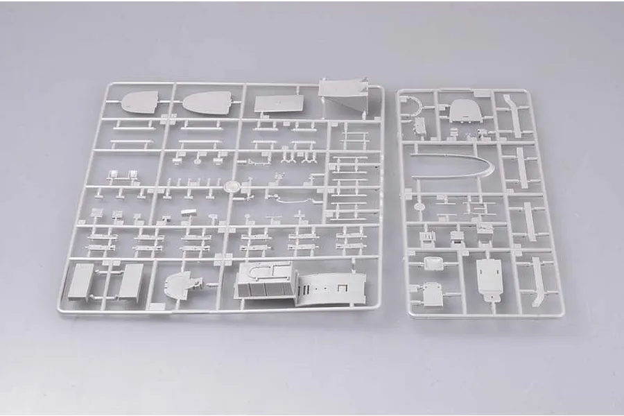Two grey plastic model kit sprues containing various aircraft parts laid out on a plain light grey background.